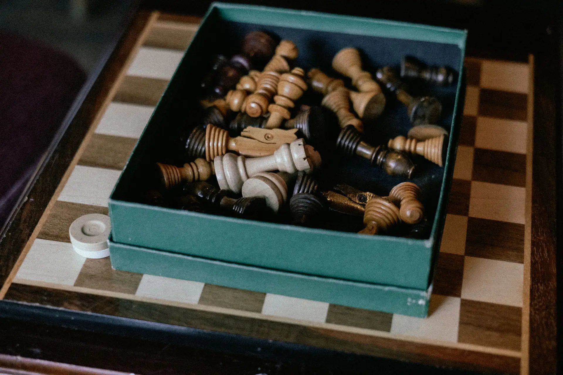 Chess set arranged beside a wooden board